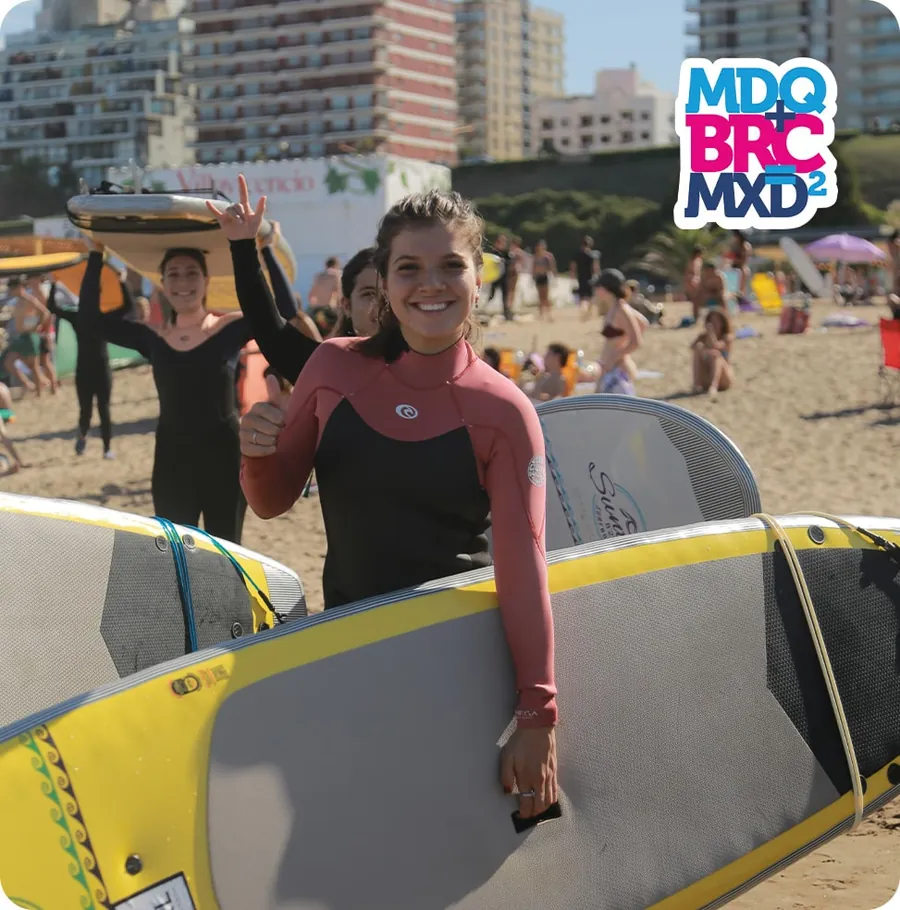 Egresada con tabla de surf en Mar del Plata