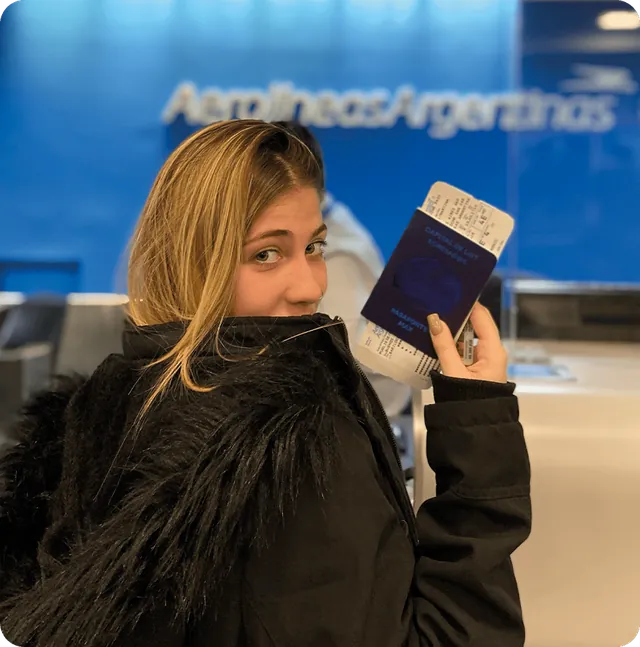 Egresada con su pasaje en el aeropuerto